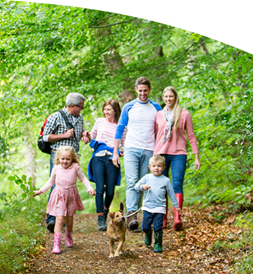 3 generations of family walking a trail in the woods