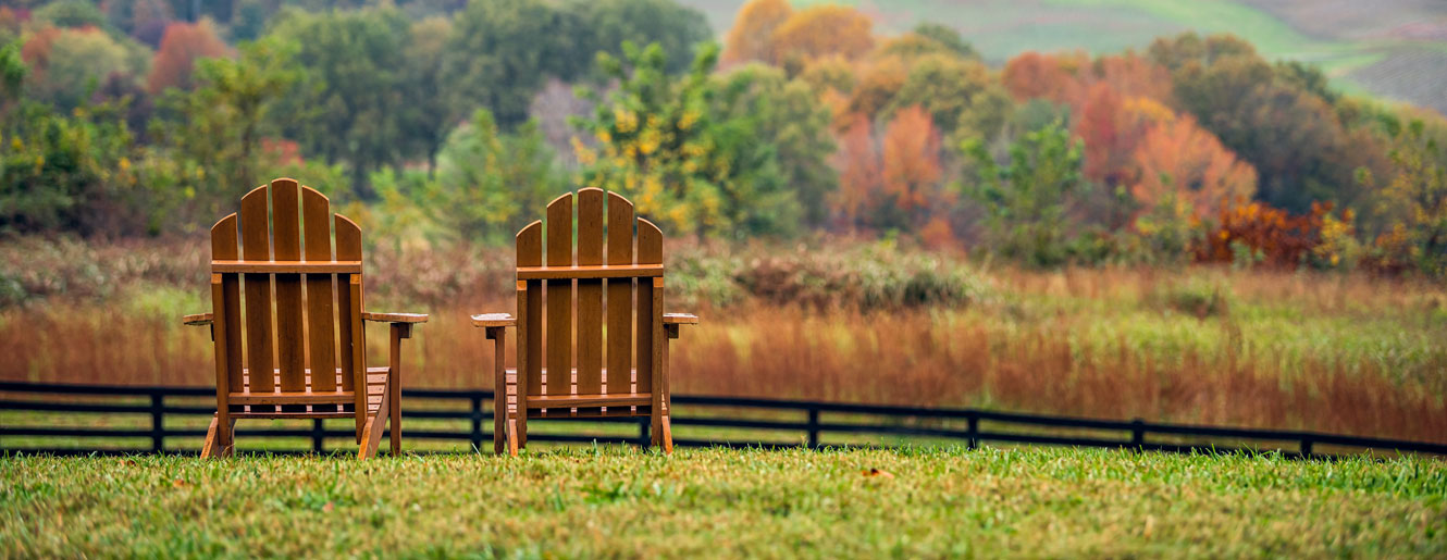 Two chairs in a field overlooking mountains