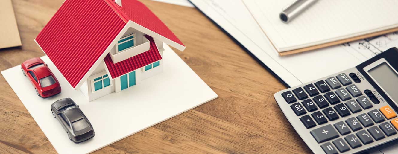 Lego house and calculator on a desk.