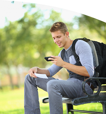 A young man making a remote deposit on a bench